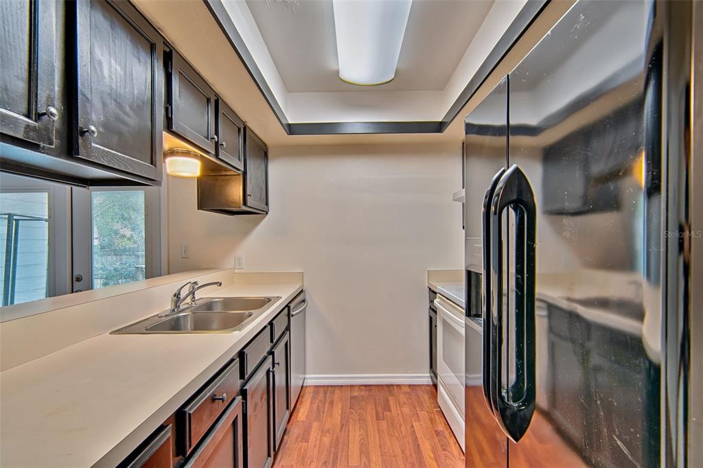 2305 Southwest 73rd Terrace Gainesville, FL 32607 - Photo 6 of 21 a kitchen with stainless steel appliances granite countertop a sink and wooden floor