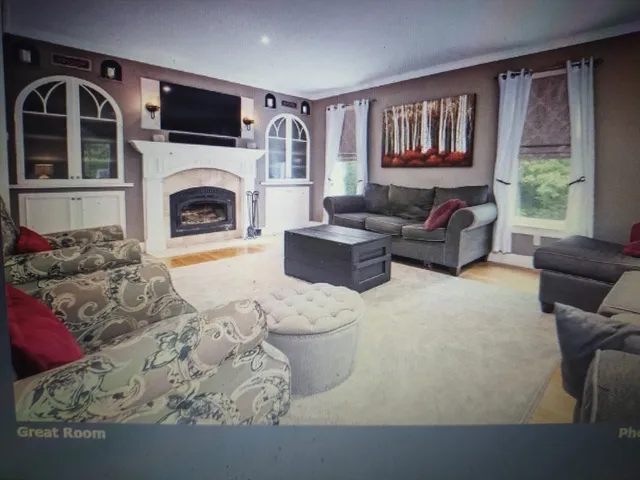 a living room with furniture a fireplace and a large window