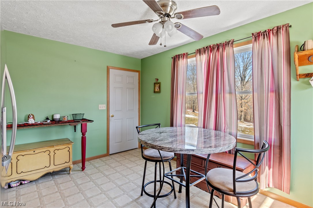 Dining area featuring ceiling fan and a textured ceiling