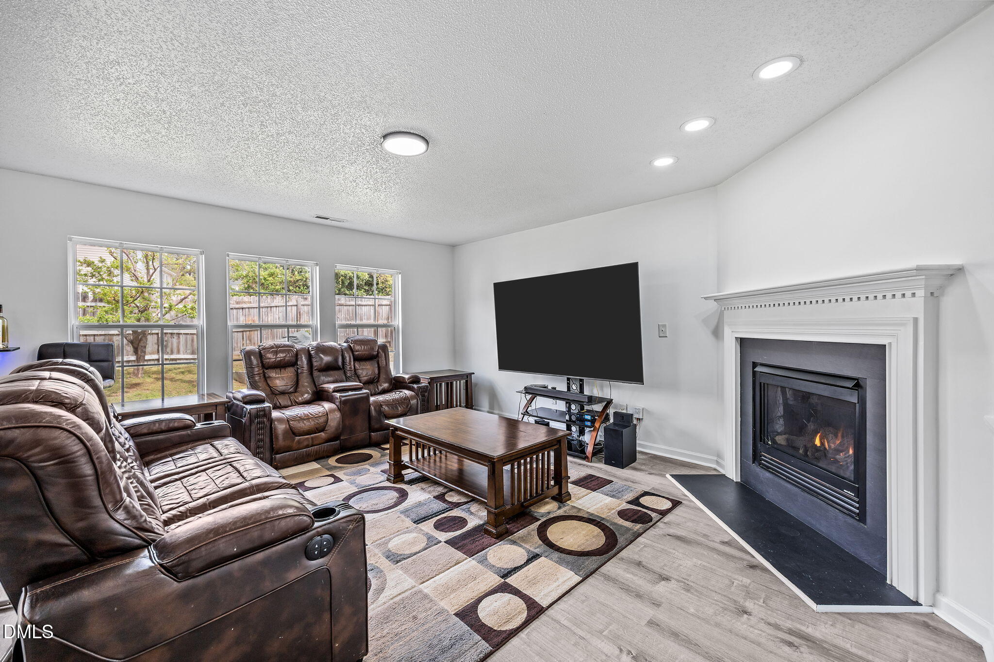 6307 Quitman Trail Raleigh, NC 27610 - Photo 11 of 35 a living room with furniture a fireplace and a flat screen tv