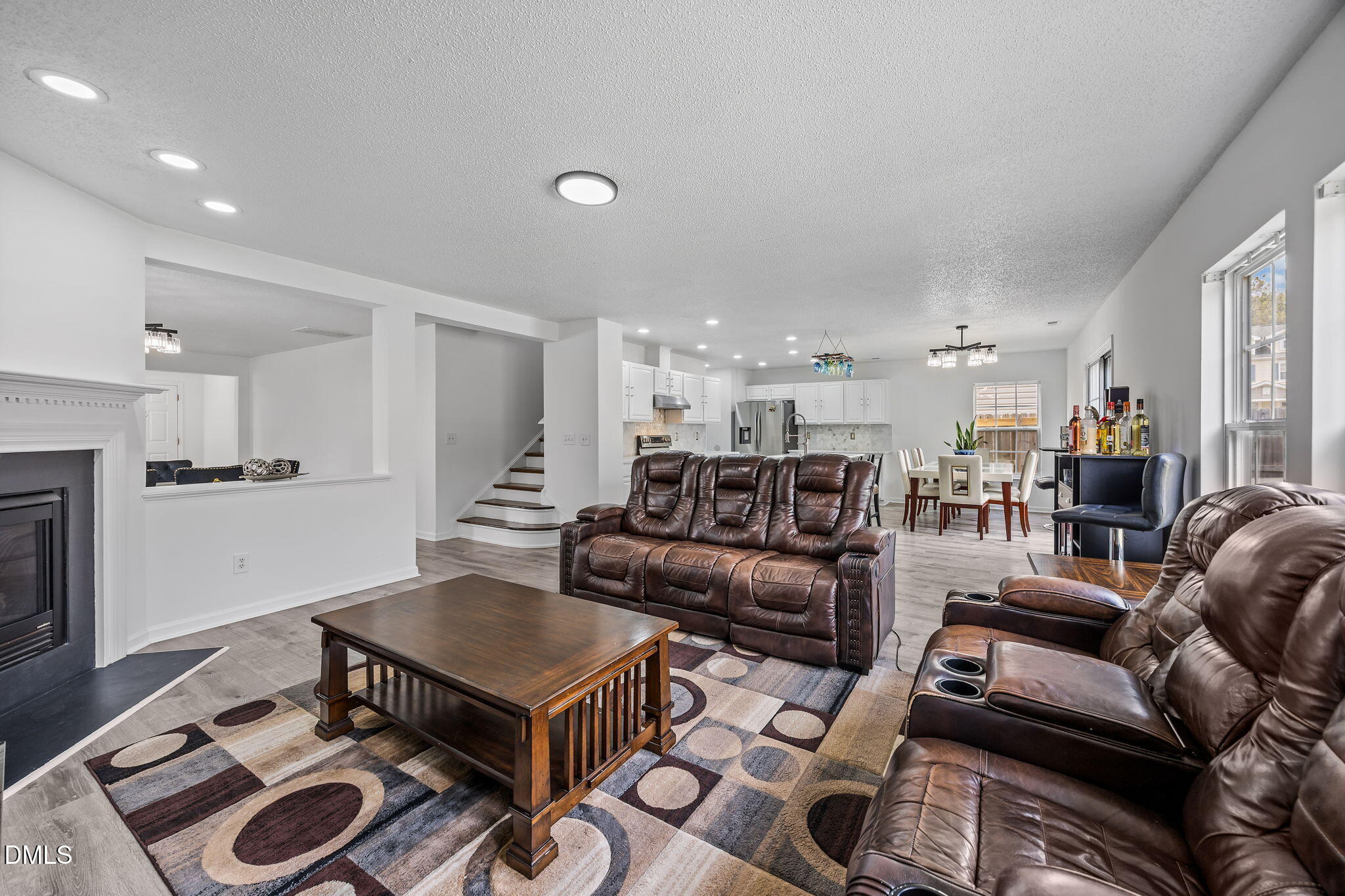 6307 Quitman Trail Raleigh, NC 27610 - Photo 12 of 35 a living room with furniture a rug kitchen view and a fireplace