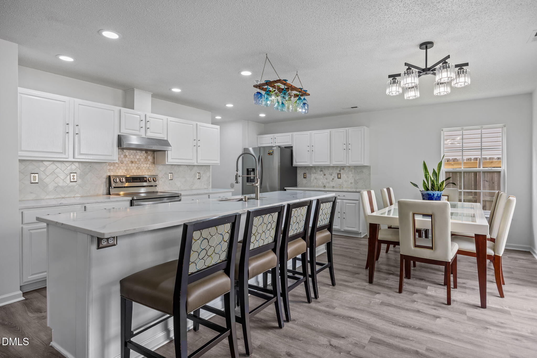 6307 Quitman Trail Raleigh, NC 27610 - Photo 21 of 35 a kitchen with kitchen island granite countertop a dining table chairs refrigerator and microwave