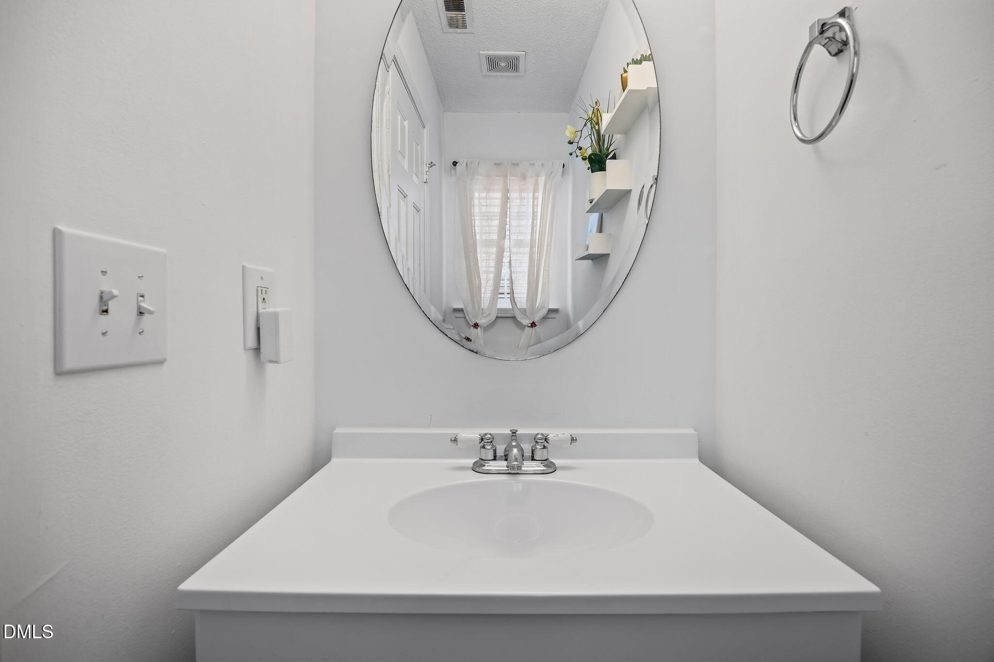 6307 Quitman Trail Raleigh, NC 27610 - Photo 22 of 35 a bathroom with a sink a mirror and a wall with view of bathroom
