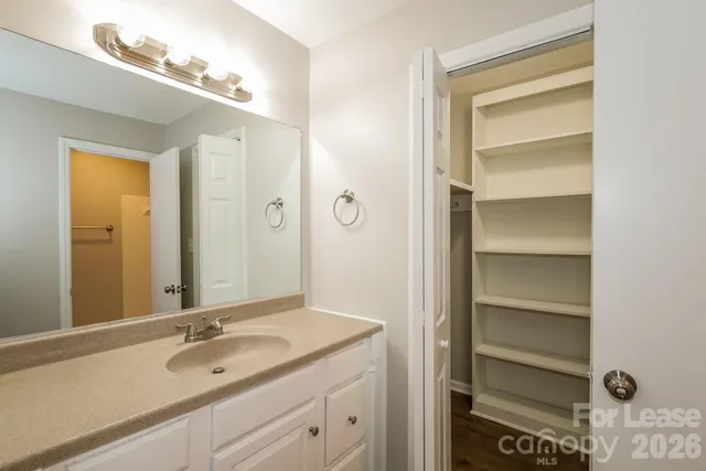 a bathroom with a granite countertop sink and a mirror