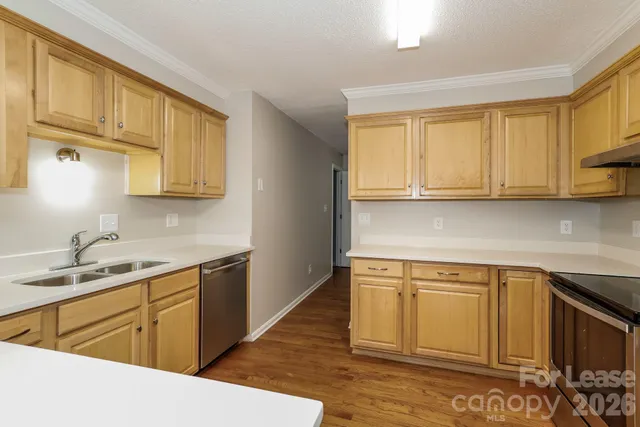 a kitchen with stainless steel appliances granite countertop a sink stove and cabinets