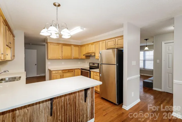 a kitchen with stainless steel appliances kitchen island a refrigerator and a stove top oven