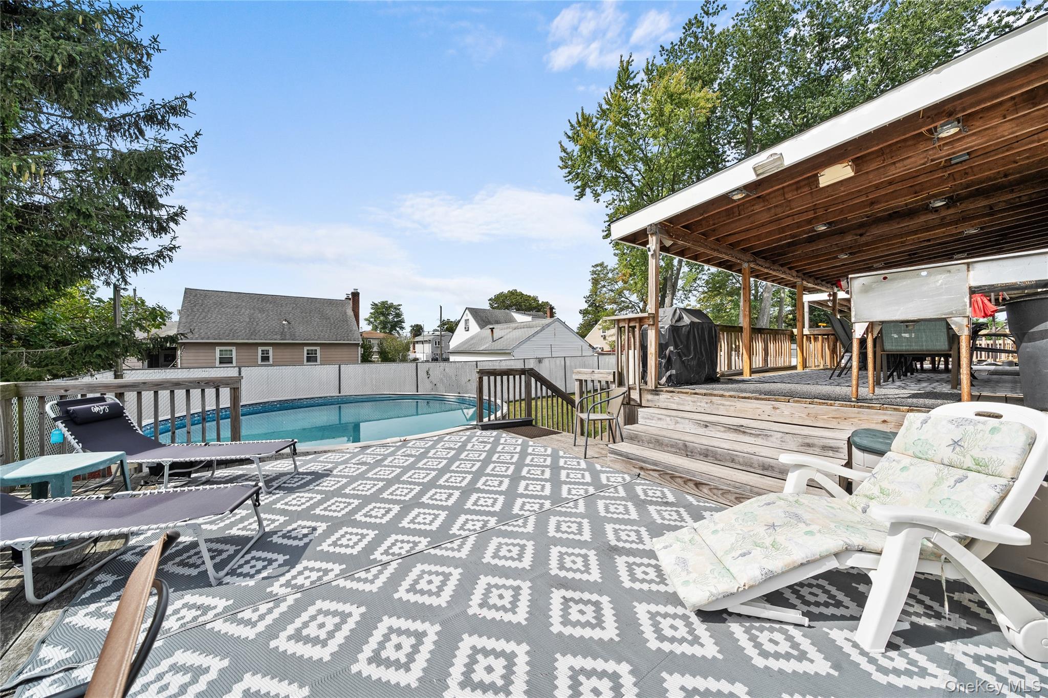34 West 21st Street Deer Park, NY 11729 - Photo 26 of 33 a view of a patio with table and chairs with wooden floor and fence