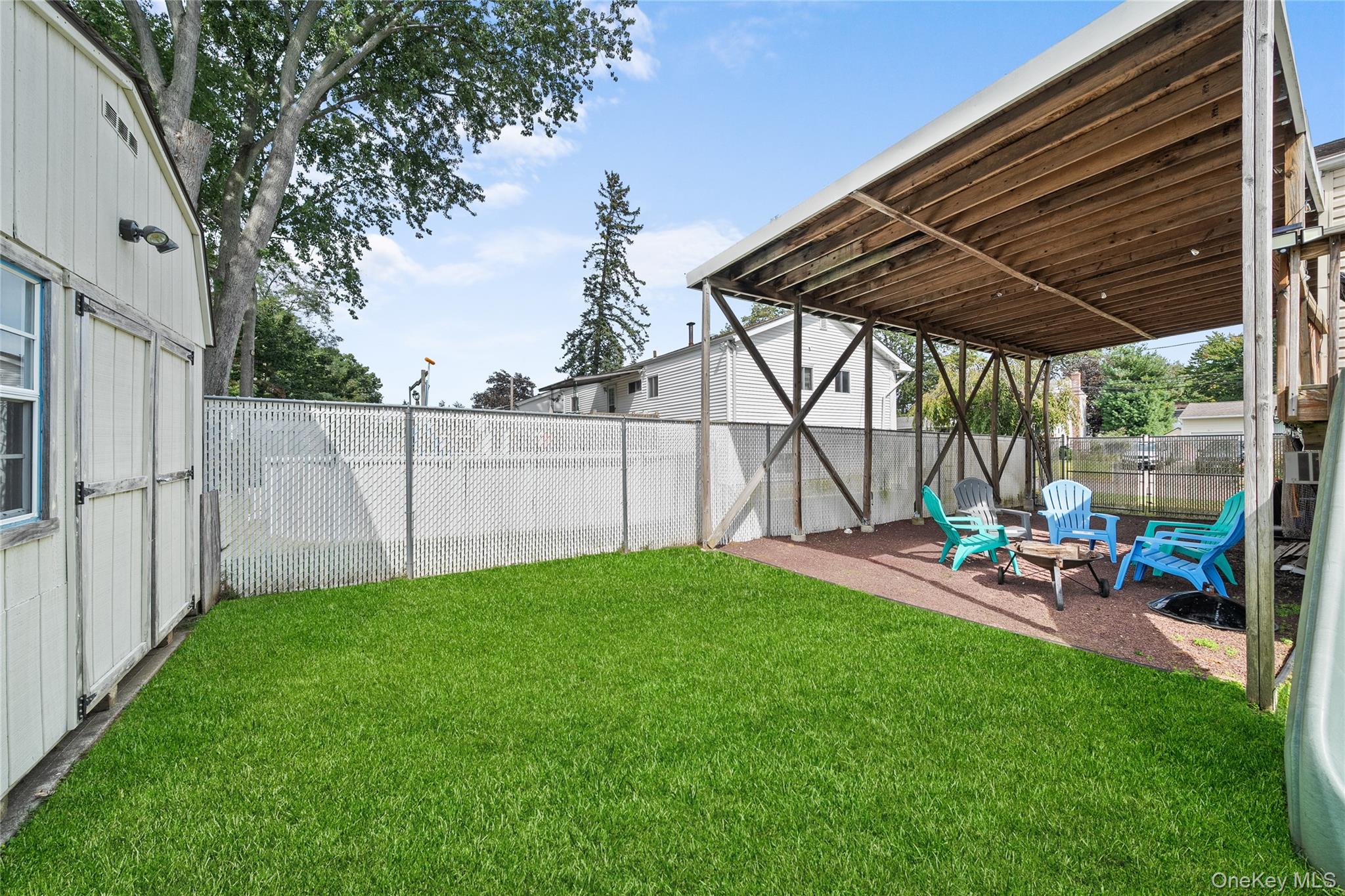 34 West 21st Street Deer Park, NY 11729 - Photo 30 of 33 a view of a backyard with table and chairs under an umbrella