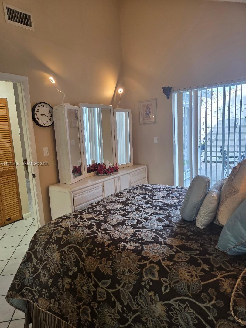 13741 Southwest 149th Cir Lane, Unit 242 Miami, FL 33186 - Photo 16 of 25 a bedroom with a bed and a large mirror