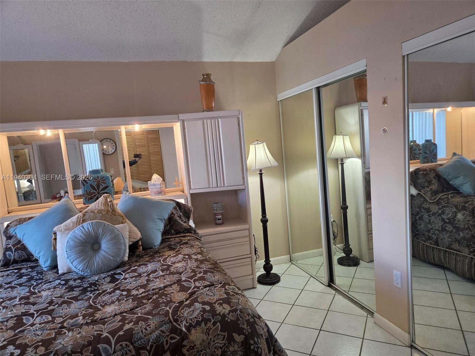 13741 Southwest 149th Cir Lane, Unit 242 Miami, FL 33186 - Photo 3 of 25 a bed room with a bed and a large mirror
