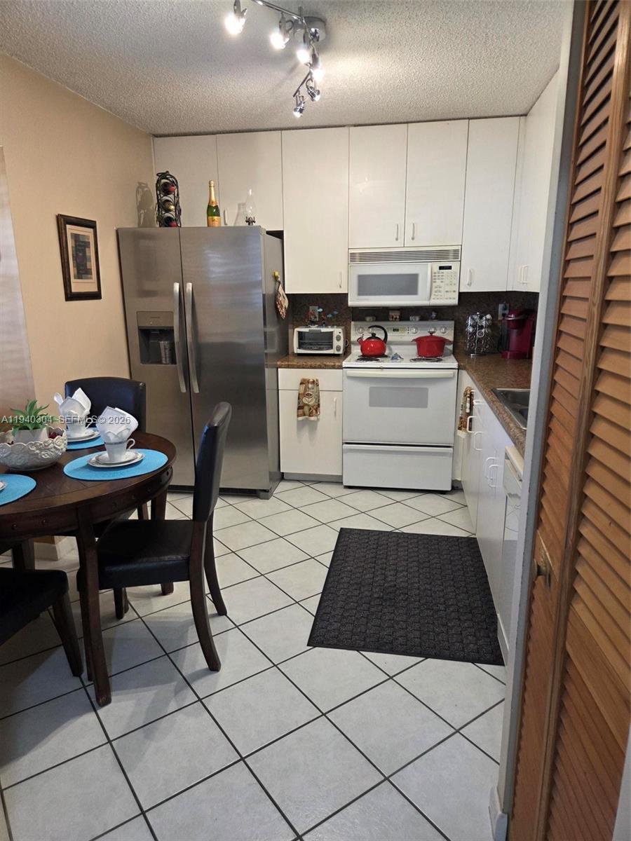 13741 Southwest 149th Cir Lane, Unit 242 Miami, FL 33186 - Photo 7 of 25 a kitchen with stainless steel appliances a refrigerator sink and cabinets