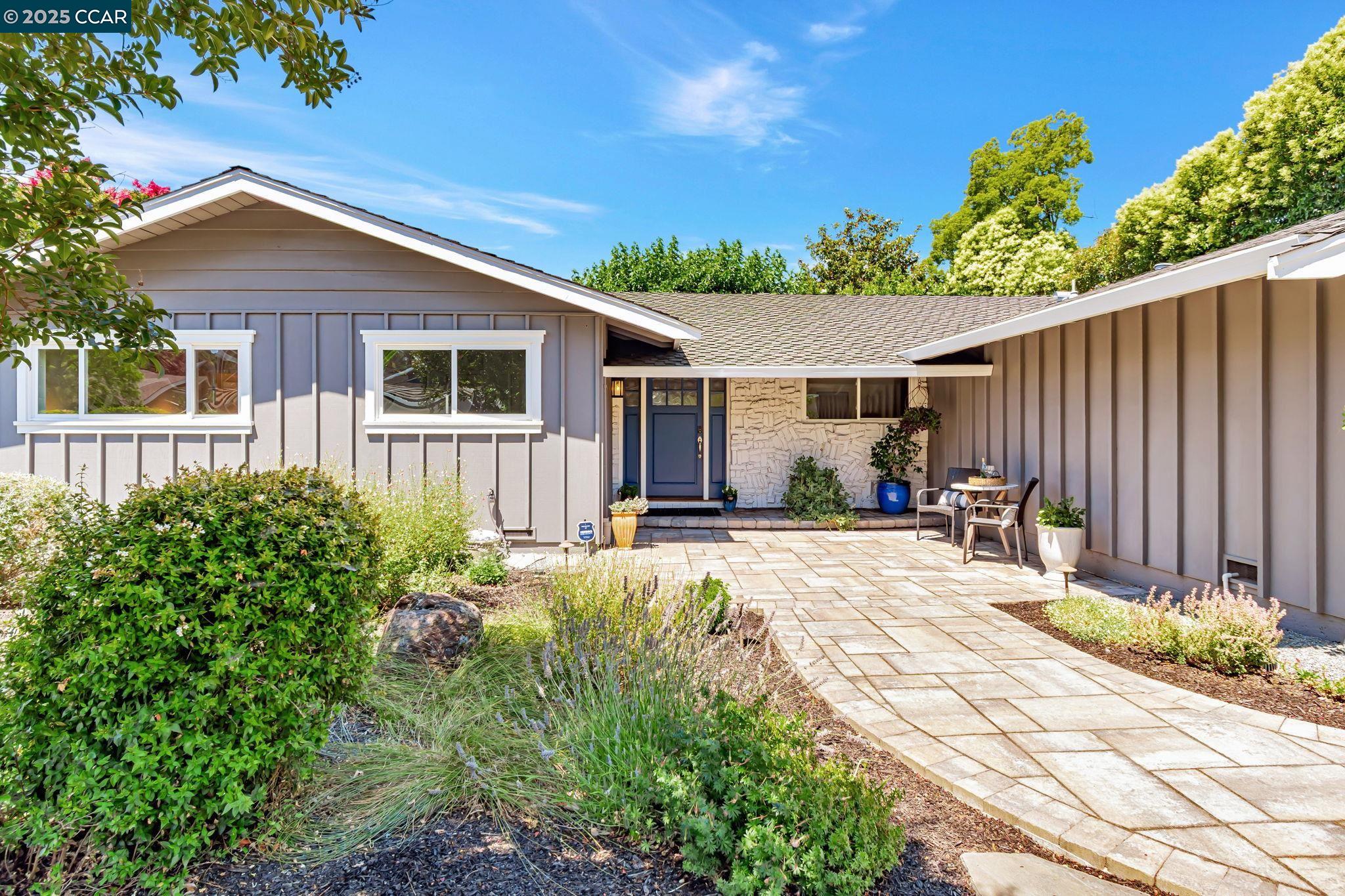 a view of a house with backyard and sitting area