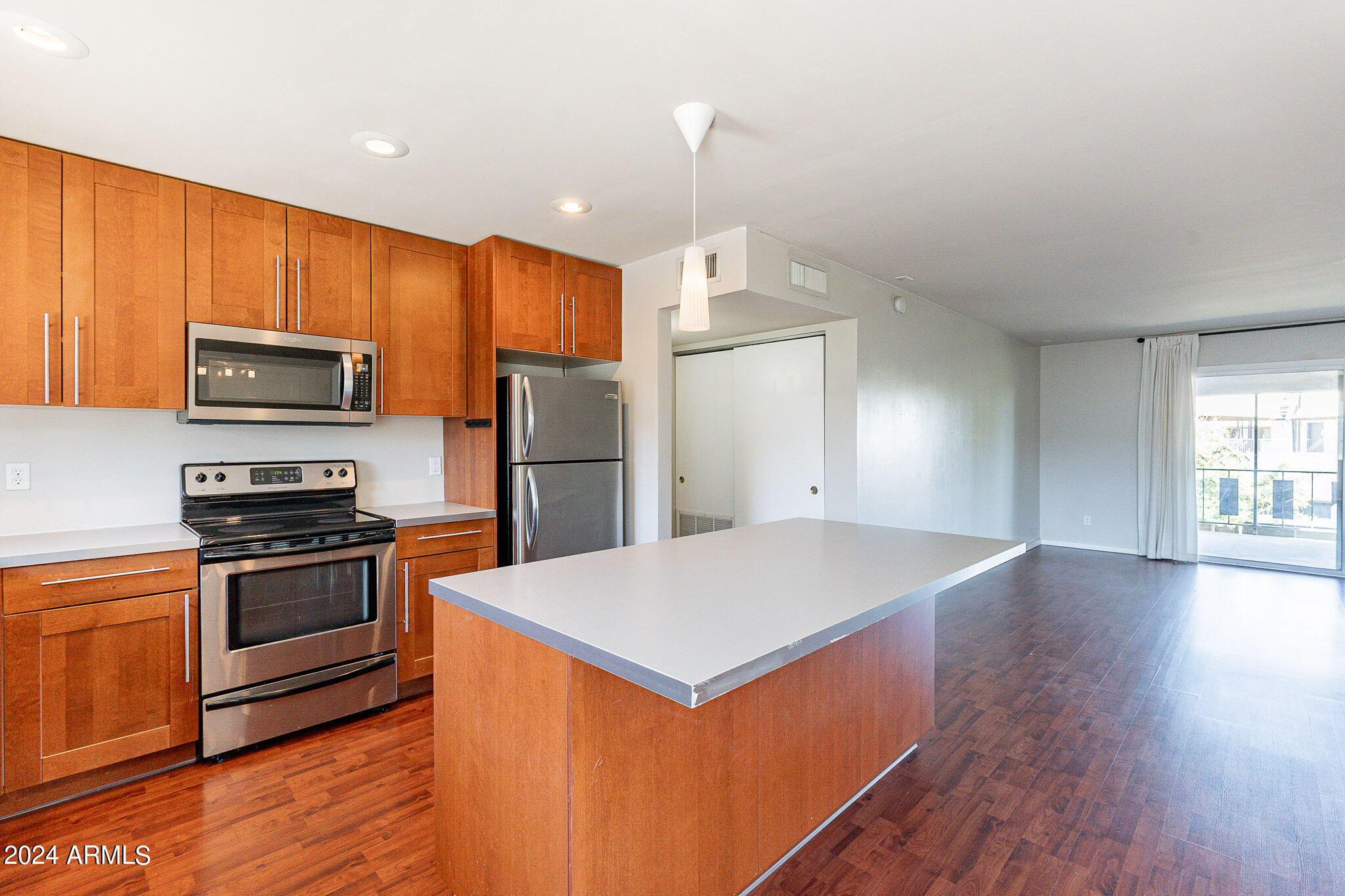 1630 East Georgia Avenue, Unit 204 Phoenix, AZ 85016 - Photo 3 of 23 a kitchen with stainless steel appliances a stove a refrigerator a sink and white cabinets with wooden floor