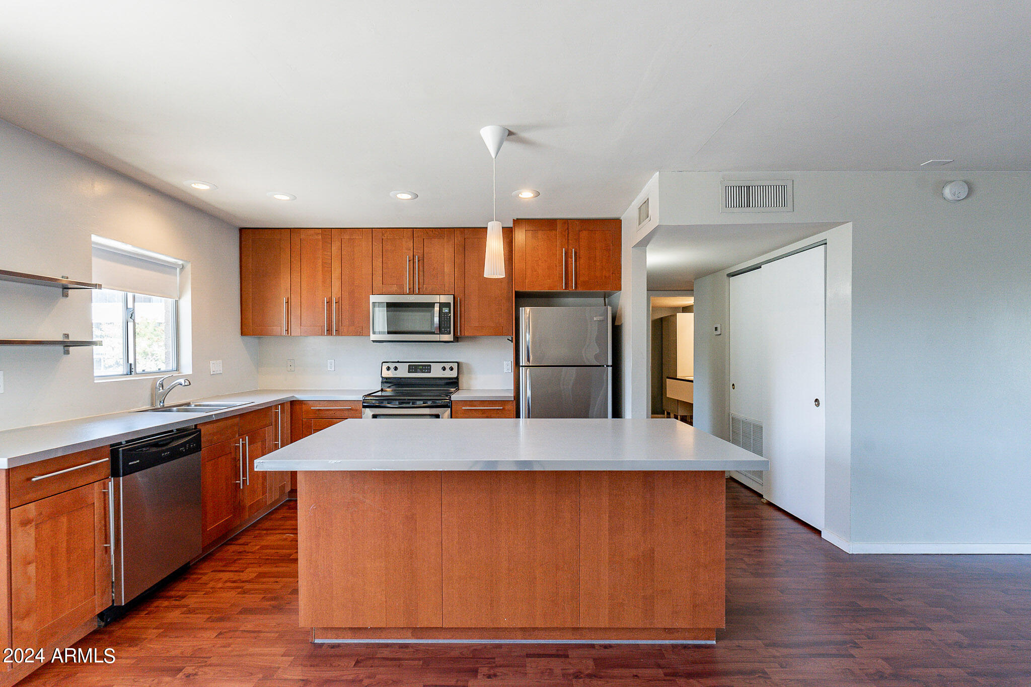 1630 East Georgia Avenue, Unit 204 Phoenix, AZ 85016 - Photo 4 of 23 a large kitchen with stainless steel appliances a large counter top a sink a stove and a refrigerator