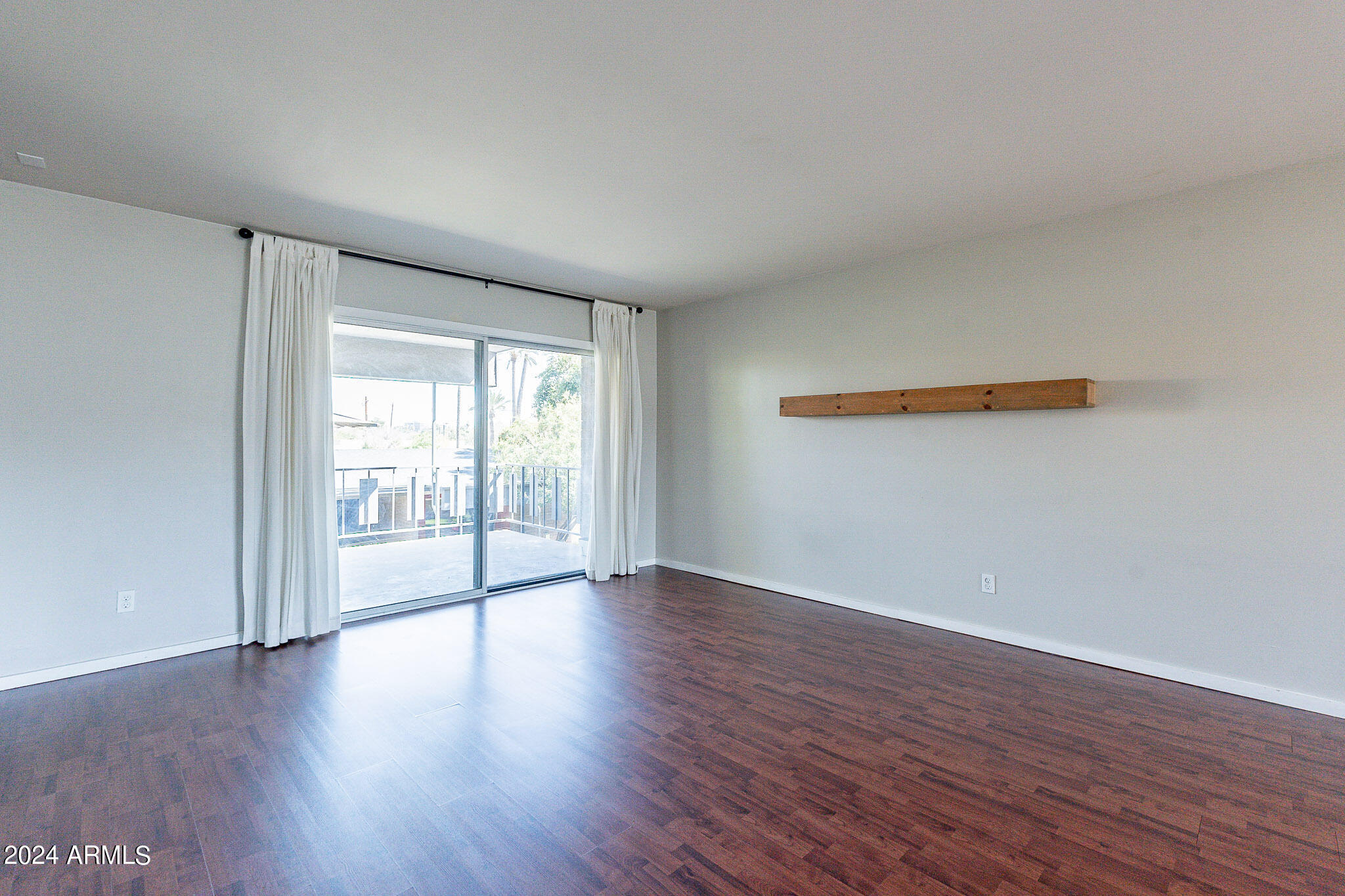 1630 East Georgia Avenue, Unit 204 Phoenix, AZ 85016 - Photo 10 of 23 a view of an empty room with wooden floor and a window