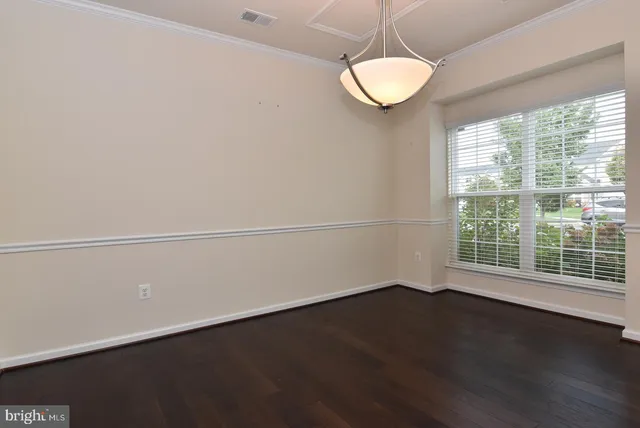 a view of a room with wooden floor and windows