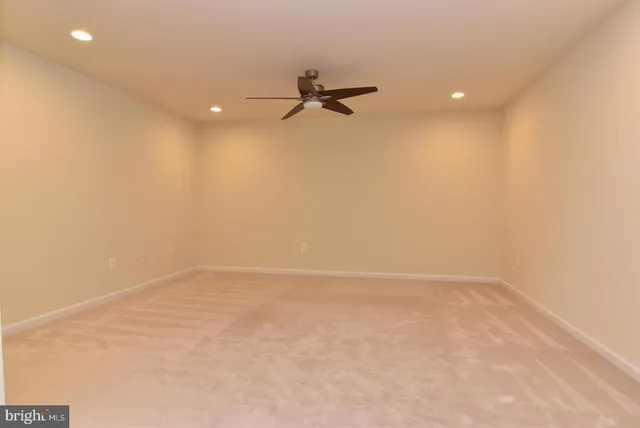 an empty room with a ceiling fan and a window