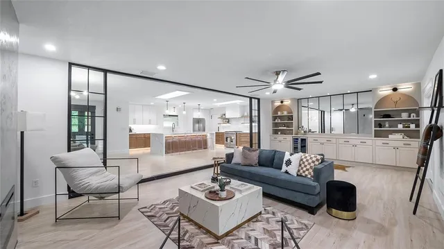a view of a livingroom with a ceiling fan and wooden floor