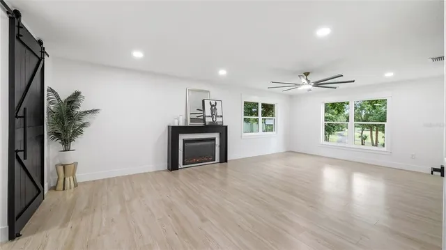 a view of a livingroom with a ceiling fan and wooden floor