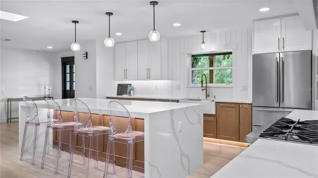 a large kitchen with stainless steel appliances kitchen island a large counter top and a wooden floors