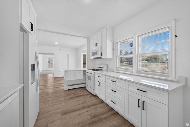220 East Greenwood Avenue Midvale, UT 84047 - Photo 11 of 46 Contemporary kitchen featuring white shaker cabinetry, quartz countertops, white appliances, and wood-finish flooring