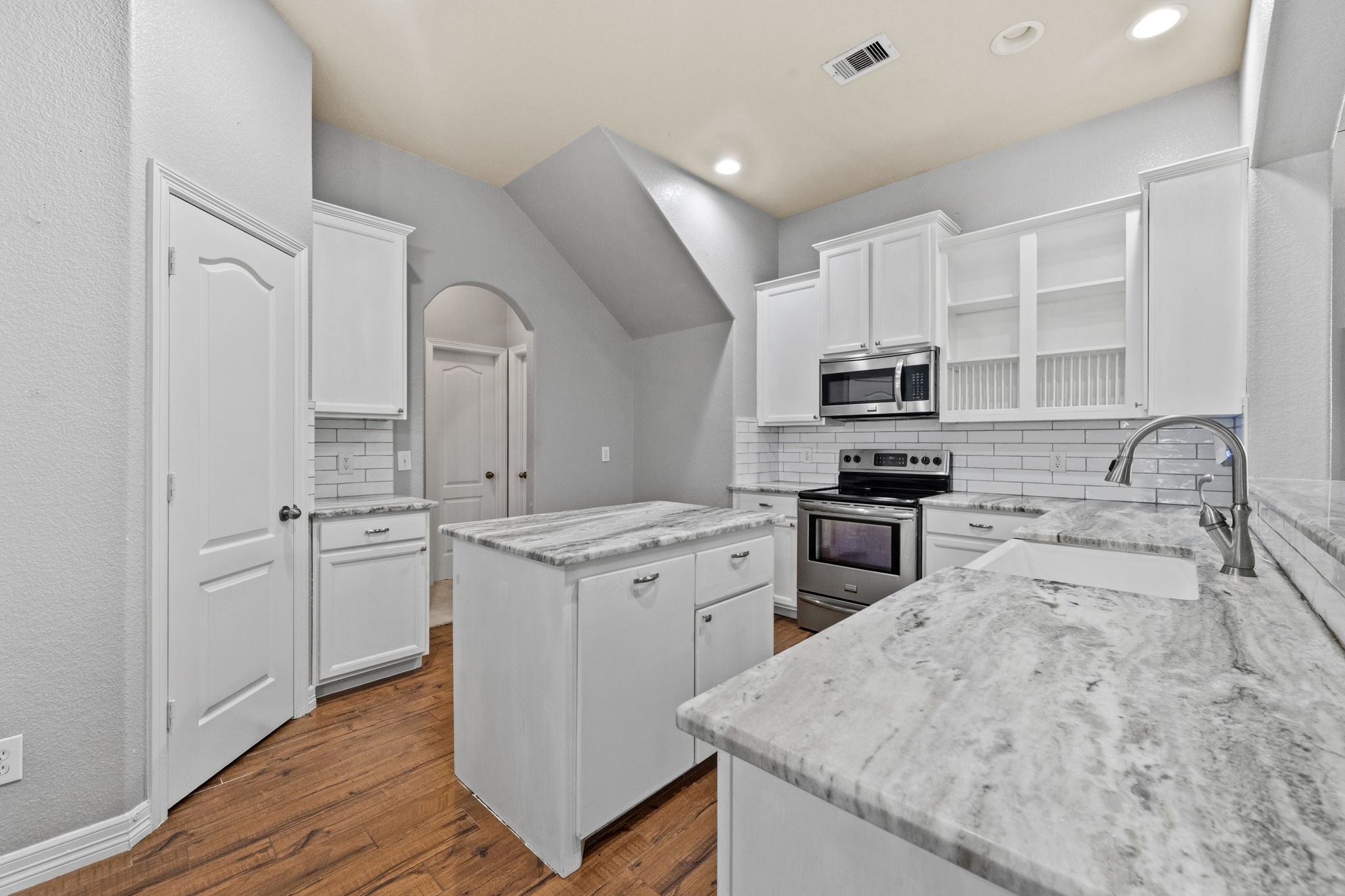 1405 Big Hill Road Winnie, TX 77665 - Photo 24 of 43 a kitchen with granite countertop a sink stainless steel appliances and white cabinets