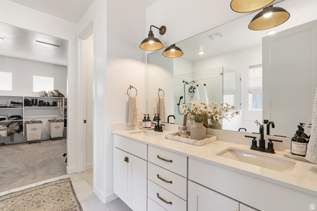 870 North Ada Loop Lehi, UT 84048 - Photo 22 of 51 Double vanity with white cabinetry and integrated sinks, complemented by matte black fixtures and overhead sconces