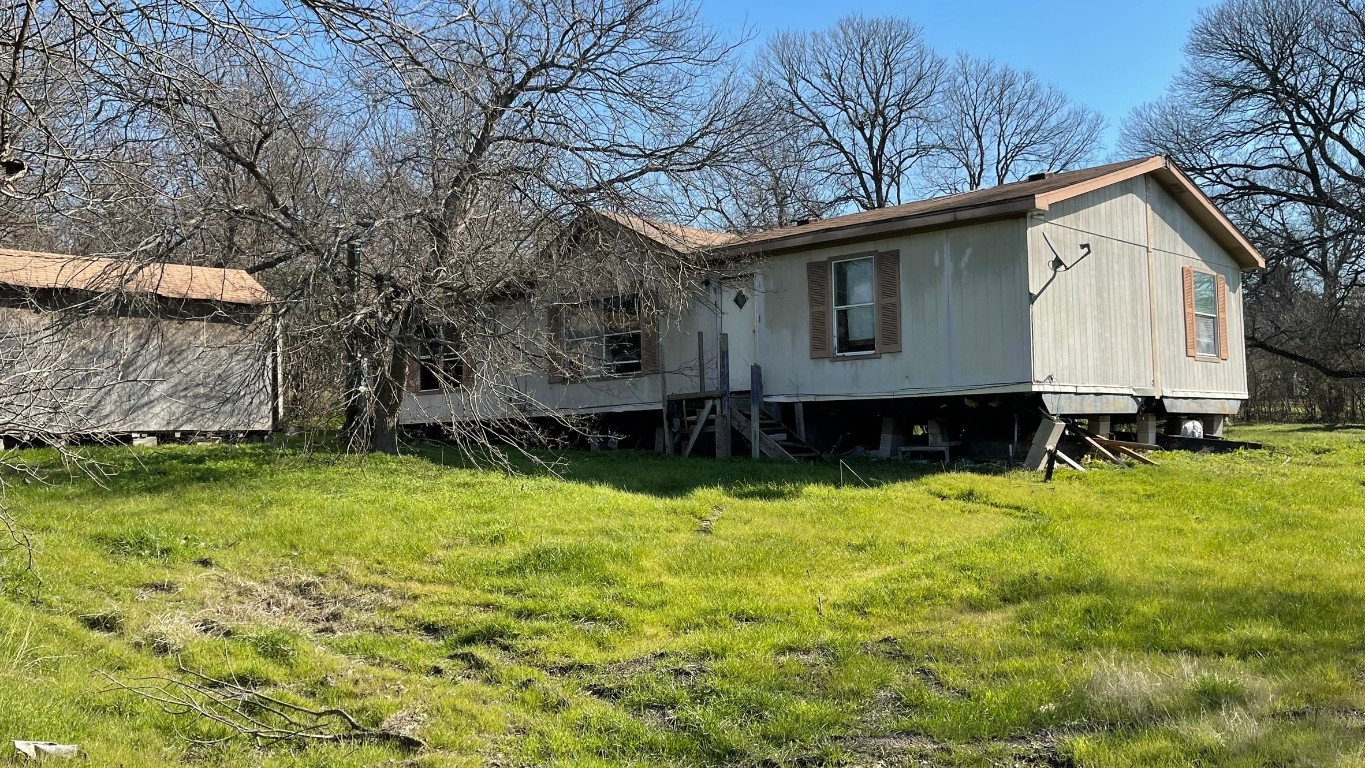 5401 Blue Bluff Road Austin, TX 78724 - Photo 1 of 1 a view of a backyard with plants and large tree