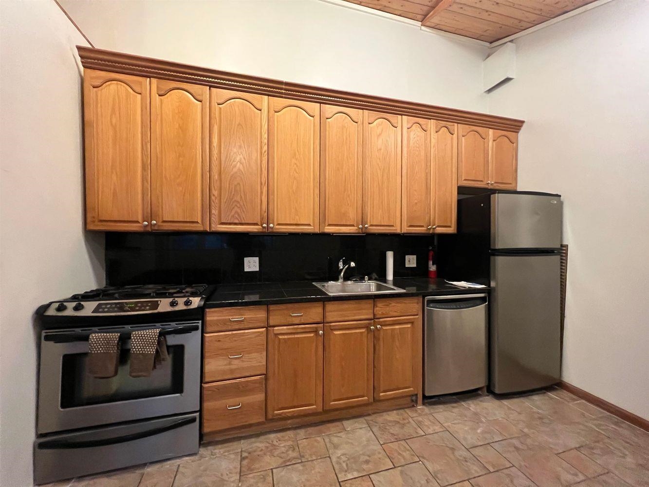334 Paterson Plank Road, Unit 1 Jersey City, NJ 07307 - Photo 9 of 20 a kitchen with stainless steel appliances granite countertop a stove a sink and a refrigerator