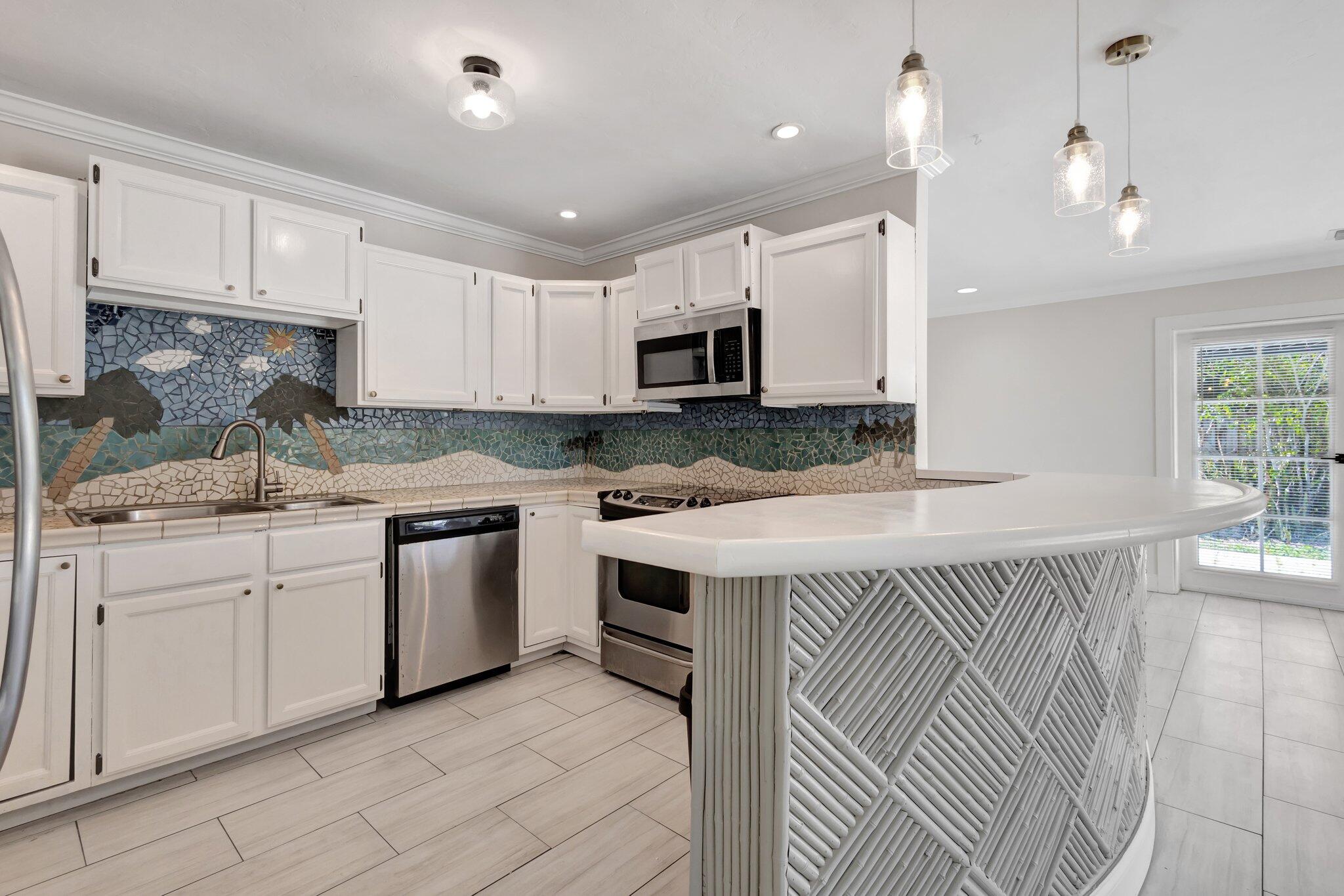 1225 16th Avenue North Lake Worth Beach, FL 33460 - Photo 1 of 18 a kitchen that has a lot of cabinets in it and appliances