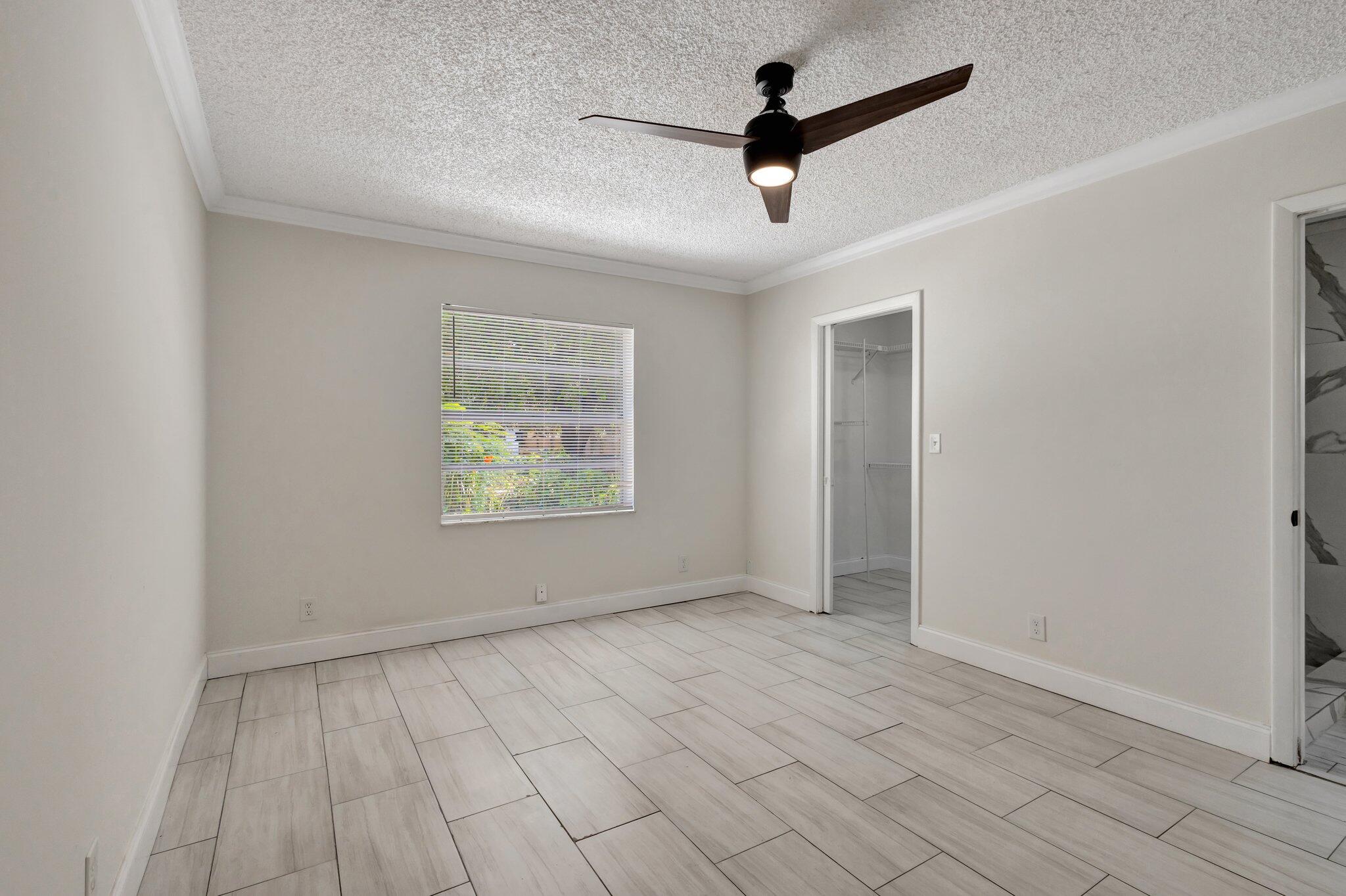 1225 16th Avenue North Lake Worth Beach, FL 33460 - Photo 10 of 18 an empty room with windows and ceiling fan