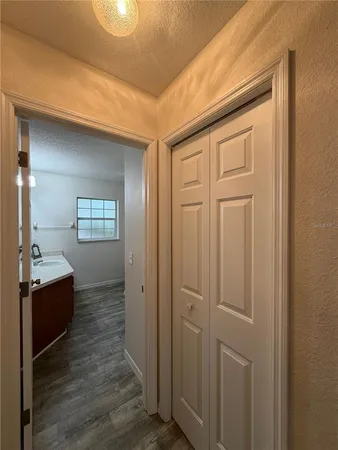 a hallway with white cabinets and wooden floor