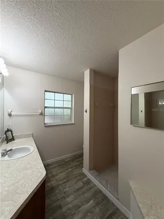 a bathroom with a granite countertop sink and mirror