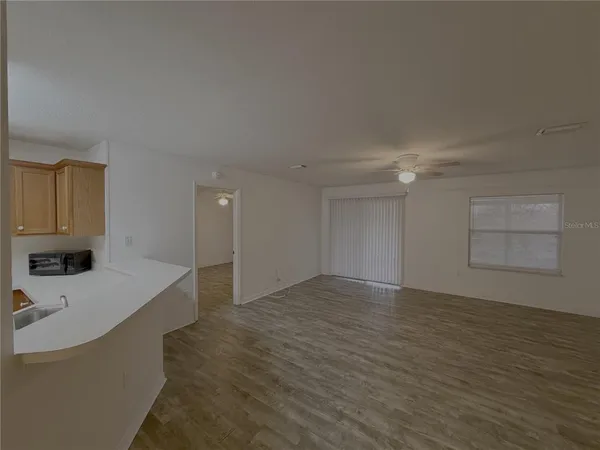 a view of a kitchen with a sink and dishwasher cabinet with wooden floor