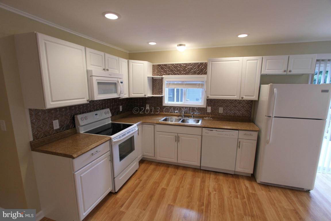 68 Sandyhook Road Ocean Pines, MD 21811 - Photo 4 of 35 a kitchen with stainless steel appliances granite countertop a refrigerator a stove a sink and white cabinets
