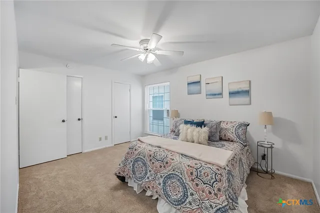 a bedroom with a large bed and a ceiling fan