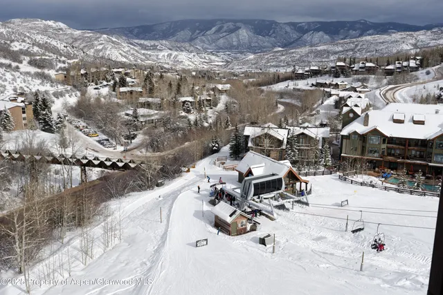a living room with furniture a rug and a book shelf