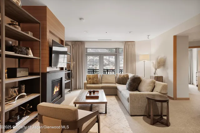 a kitchen with stainless steel appliances granite countertop a table chairs in it and wooden floors