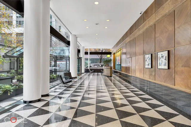 a hallway with a black white checkered floor and a large window