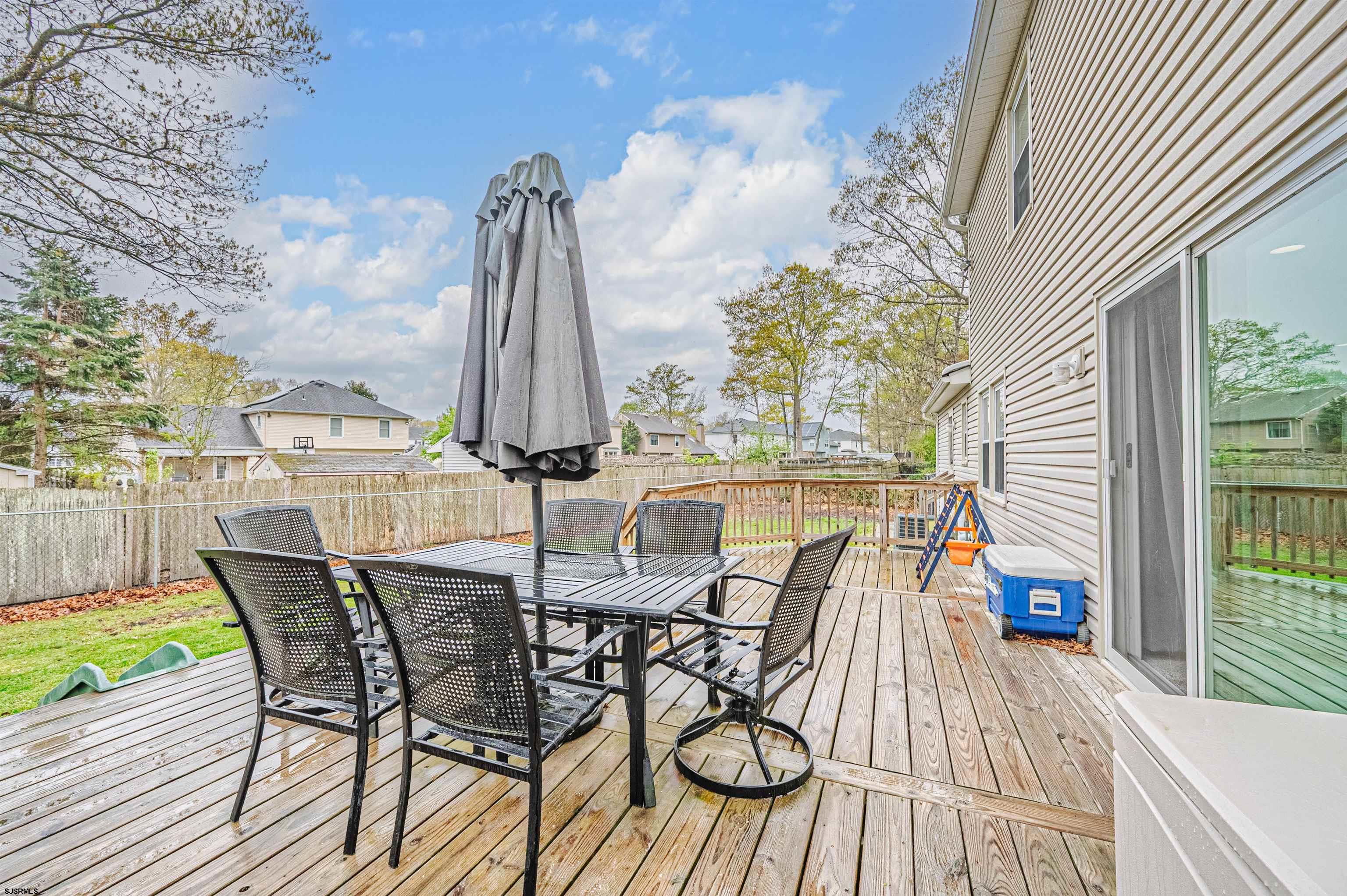 9 Rook Court Egg Harbor Township, NJ 08234 - Photo 21 of 27 a view of a roof deck with table and chairs with wooden floor and fence