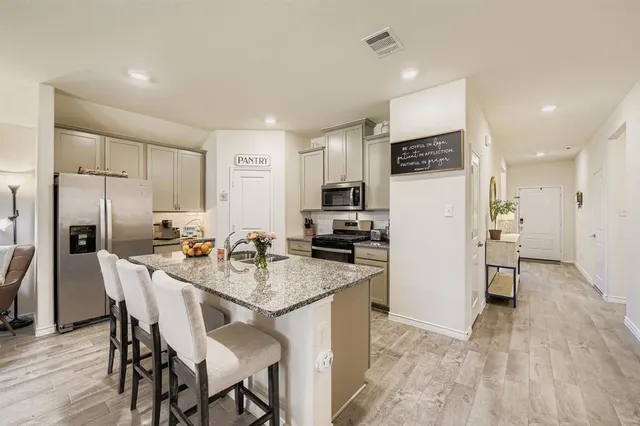 a kitchen with kitchen island wooden cabinets and stainless steel appliances
