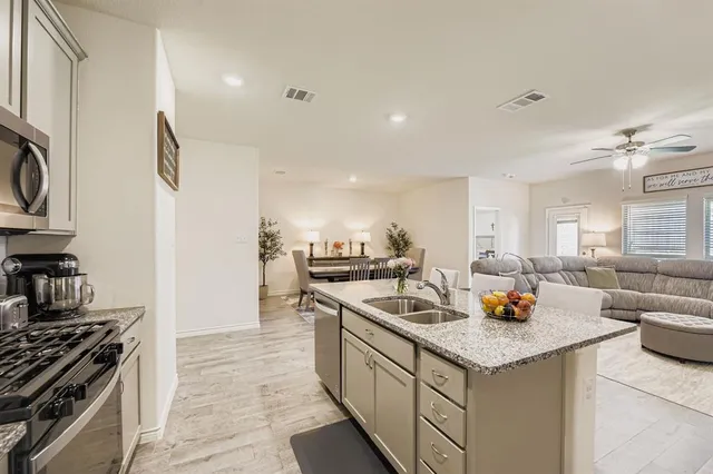 a large kitchen with a table chairs refrigerator and a stove top oven