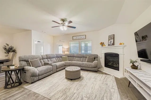 a living room with furniture a flat screen tv and a fireplace