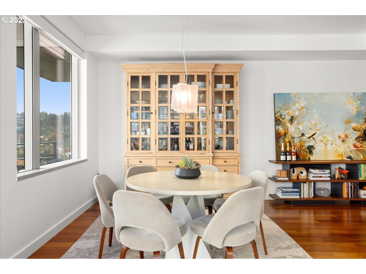841 Southwest Gaines Street, Unit 1800 Portland, OR 97239 - Photo 19 of 39 a dining room with wooden floor and large windows