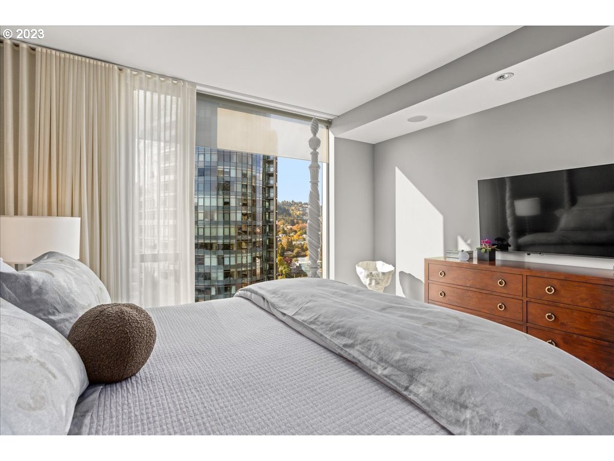 841 Southwest Gaines Street, Unit 1800 Portland, OR 97239 - Photo 24 of 39 a bedroom with a large bed and a flat screen tv