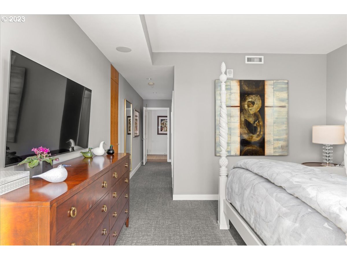 841 Southwest Gaines Street, Unit 1800 Portland, OR 97239 - Photo 26 of 39 a bedroom with a bed and a flat screen tv