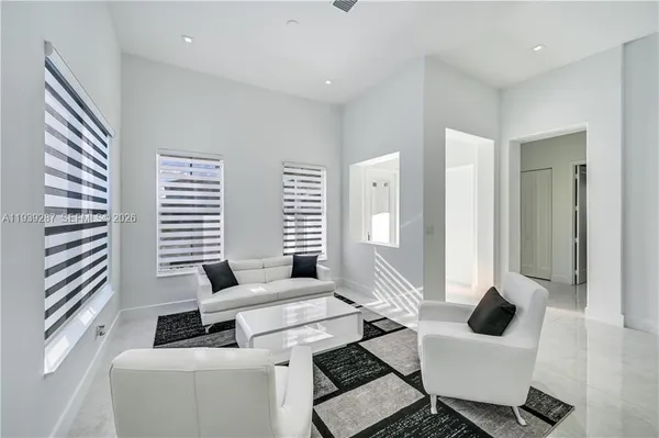 a living room with furniture and floor to ceiling windows