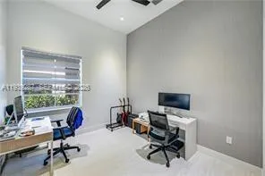 a view of a workspace with furniture and a window