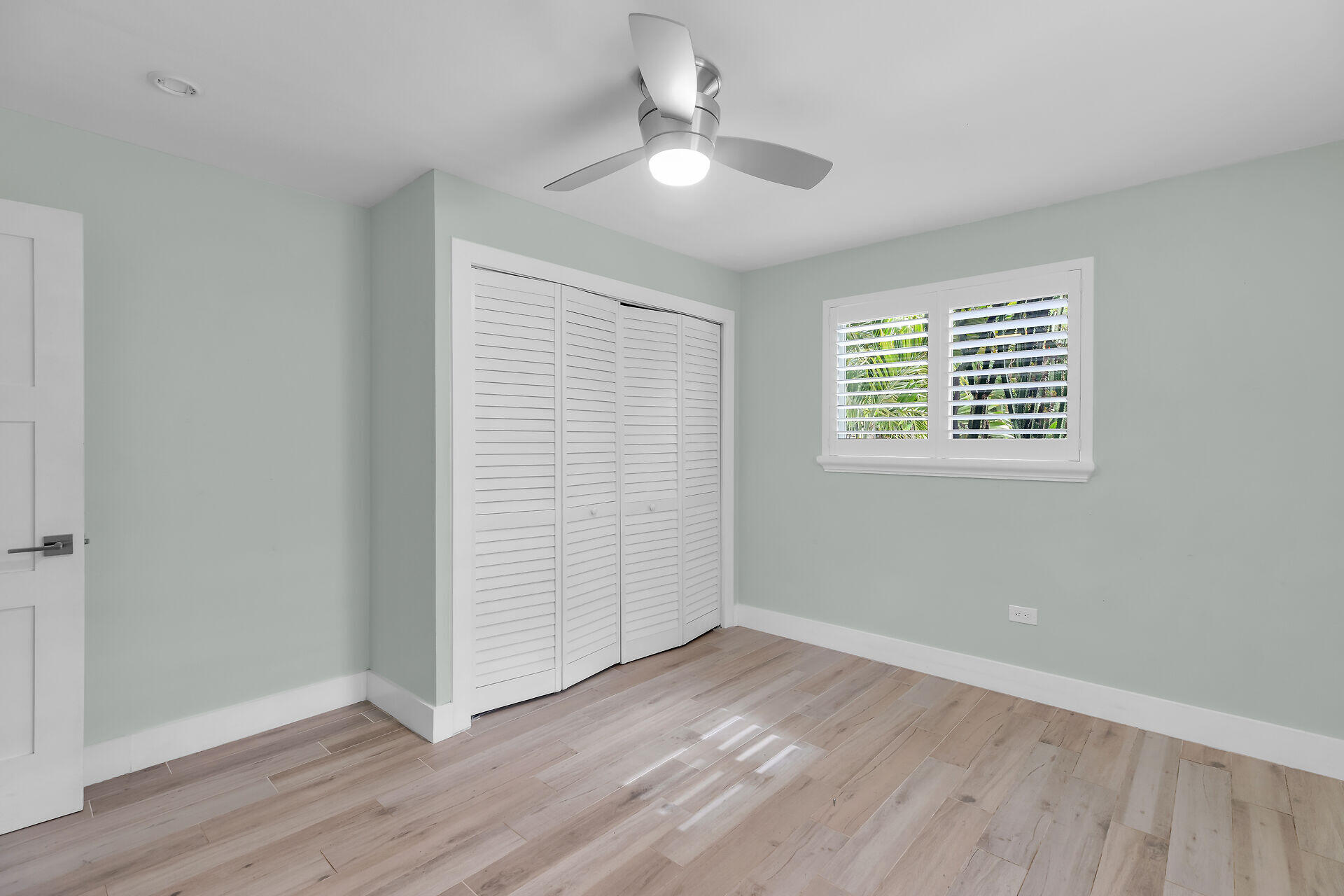 535 Plante Street Key Largo, FL 33037 - Photo 27 of 47 an empty room with wooden floor chandelier fan and windows