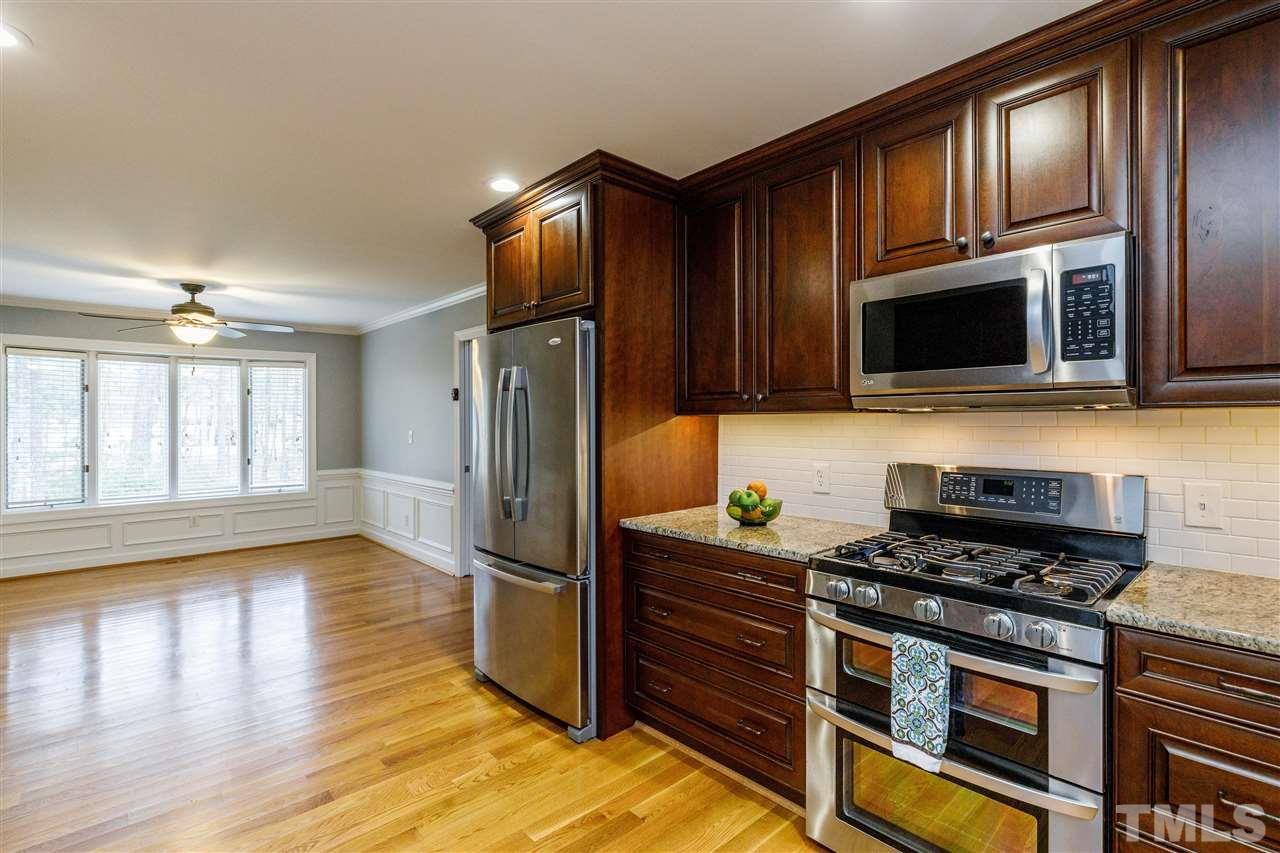 2921 Old Milburnie Road Raleigh, NC 27604 - Photo 6 of 27 a kitchen with granite countertop a refrigerator and a stove top oven